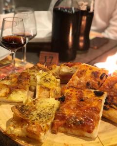 a group of slices of pizza on a table with a glass of wine at Agriturismo Borgo Furma in Enna