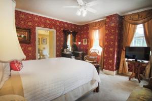 a bedroom with a large white bed and red wallpaper at Amelia Island Williams House in Fernandina Beach