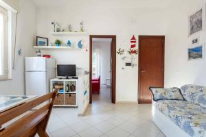 a living room with a couch and a refrigerator at Il Fascino della Sirena - Sea House in Giardini Naxos