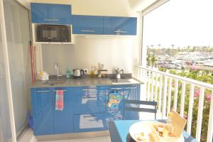 cocina con armarios azules y balcón en L'oasis de Saint-François, studio An bel ti koté en Saint-François