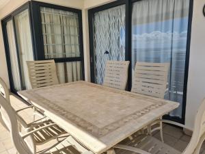 a dining table and chairs on a balcony at Point Village Accommodation - Santos 57 in Mossel Bay