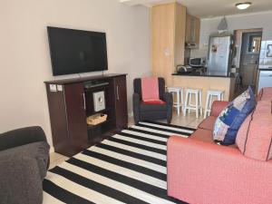 een woonkamer met 2 banken en een flatscreen-tv bij Point Village Accommodation - Santos 57 in Mosselbaai