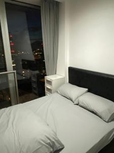 uma cama branca num quarto com uma janela em Rotunda - New Street, City Centre, Birmingham em Birmingham