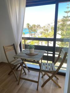 a wooden table and two chairs on a balcony at Apartamento Vista Altillo in Almuñécar