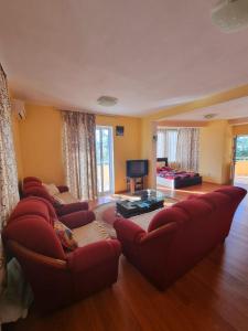 sala de estar con sofás rojos y TV en Grandino rooms&apart, en Ulcinj