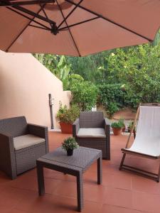 patio z 2 krzesłami i parasolem w obiekcie Chirone Room w mieście Mondello
