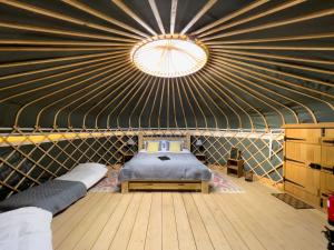 um quarto com uma cama numa tenda com tecto em Wild Meadow, Lodge Farm, East Raynham em Fakenham