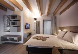 Schlafzimmer mit einem großen Bett mit weißer Bettwäsche und Holzdecken in der Unterkunft Casa Alla Lega in Arco