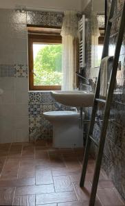 a bathroom with a sink and a tub and a window at Le Farine Del Maestro in Barete