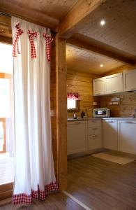 una cucina con tenda rossa e bianca in una cabina di Le Farine Del Maestro a Barete