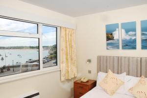a bedroom with a bed and a large window at Dolphin Hotel in Gorey