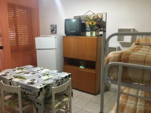 a room with a bed and a table and a tv at Residence La Quiete in Taureana