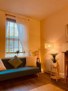 un soggiorno con divano blu e finestra di 'Bloomfield' at stayBOOM a Lancaster