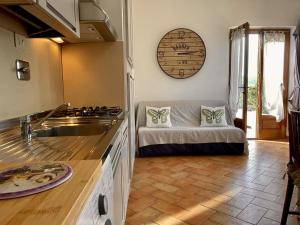 een keuken met een bank in het midden van een kamer bij Sera & Mattino Appartamenti by SolturElba in Capoliveri