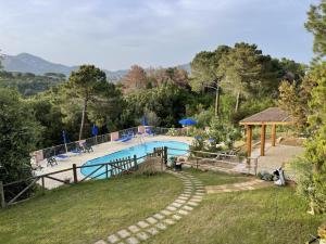 een groot zwembad in een tuin met een heuvel bij Sera & Mattino Appartamenti by SolturElba in Capoliveri