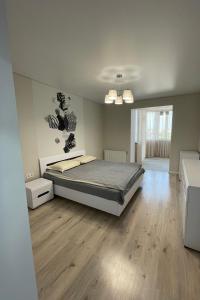 a bedroom with a bed and a wooden floor at VIP Апартаменти подобово in Lutsk