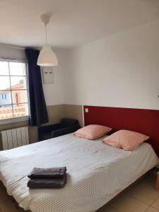 een slaapkamer met een bed met twee kussens erop bij Maison le Havre de la Gachère, 2 chambres, 2 salles d'eau, parking privé et jardin in Brem-Sur-Mer