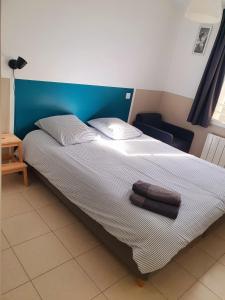 een bed met twee handdoeken in een kamer bij Maison le Havre de la Gachère, 2 chambres, 2 salles d'eau, parking privé et jardin in Brem-Sur-Mer