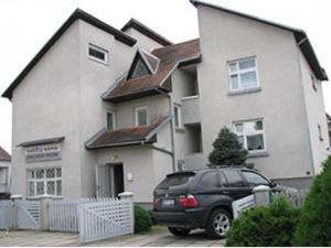 a black car parked in front of a house at Sveciu Namai Giles in Alytus