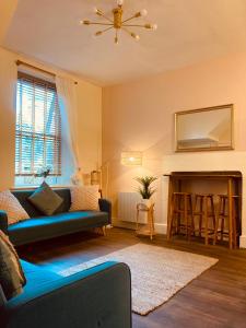 a living room with a blue couch and a fireplace at 'Bloomfield' at stayBOOM in Lancaster