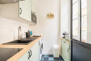 uma cozinha com pia e bancada em HOTEL DE VILLE BORDEAUX GRAND T2 STANDING em Bordéus mais 10 fotografias