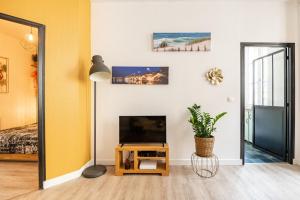 uma sala de estar com uma TV e um espelho em HOTEL DE VILLE BORDEAUX GRAND T2 STANDING em Bordéus