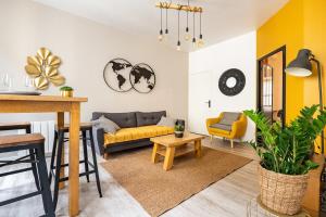 uma sala de estar com um sofá amarelo e uma mesa em HOTEL DE VILLE BORDEAUX GRAND T2 STANDING em Bordéus