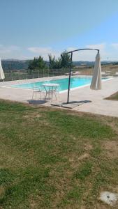 uma mesa e cadeiras ao lado de uma piscina em Country Relais La Torretta Baronale em San Giorgio del Sannio