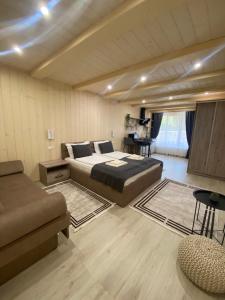 sypialnia z łóżkiem i kanapą w pokoju w obiekcie Smerekova Hata w mieście Miżhirja