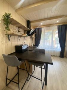 een eetkamer met een tafel en 2 stoelen bij Smerekova Hata in Mizhhirya