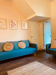 un sofá azul sentado en una sala de estar en 'Bloomfield' at stayBOOM en Lancaster