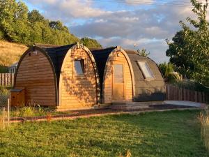 a tiny house in a yard with a fence at Owl Glamping Pod in Leighton