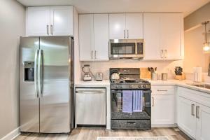 a kitchen with stainless steel appliances and white cabinets at Updated Retreat 2 Mi to Truist Park and Battery in Atlanta