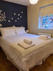 - une chambre avec un grand lit et 2 serviettes dans l'établissement Spacious 4 bed home in a quiet cul-de-sac, à Coundon