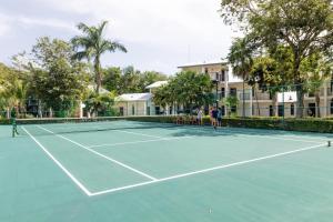 einen Tennisplatz mit zwei Personen, die darauf stehen in der Unterkunft Riu Lupita - All Inclusive in Playa del Carmen