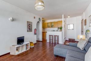 Il comprend un salon avec un canapé et une cuisine. dans l'établissement Bright 1BDR Apartment W/Balcony & Pool by LovelyStay, à Silves