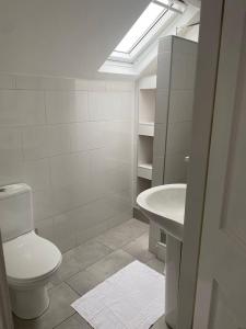 里茲的住宿－Spacious house with 3 ensuite bedrooms in Leeds，白色的浴室设有卫生间和水槽。
