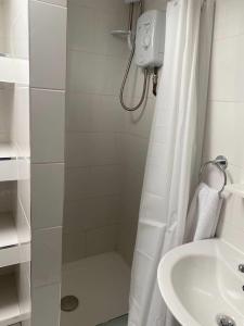 a bathroom with a shower curtain and a sink at Spacious house with 3 ensuite bedrooms in Leeds in Leeds