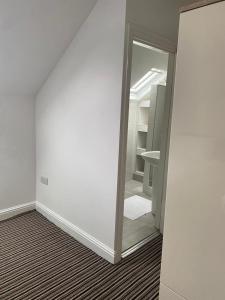里茲的住宿－Spacious house with 3 ensuite bedrooms in Leeds，一个空房间,带有镜子和衣柜