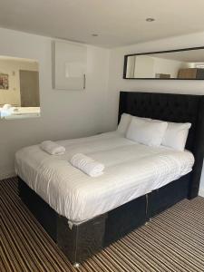 a bed with white sheets and pillows in a room at Spacious house with 3 ensuite bedrooms in Leeds in Leeds