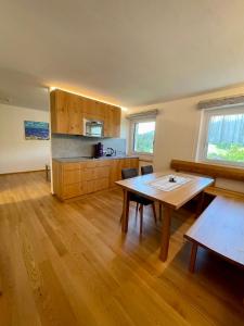 eine Küche mit einem Holztisch und Holzböden in der Unterkunft Pension & Gasthof zur Taube in Sulzberg