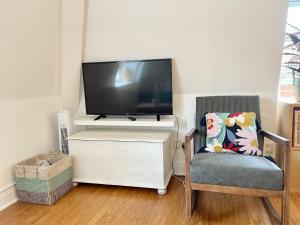 a tv sitting on top of a white dresser with a chair at Bright 1 bed flat near Cabot Circus in Bristol