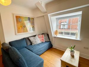 a living room with a blue couch and a window at Bright 1 bed flat near Cabot Circus in Bristol