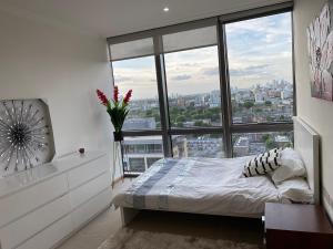 um quarto com uma cama e uma grande janela em 1 Bed- Dedicated Workspace, Coffee maker 4KTV em Londres