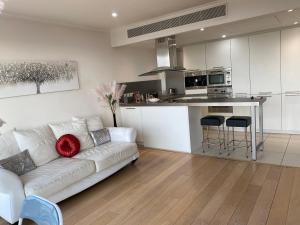 a living room with a white couch and a kitchen at 1 Bed- Dedicated Workspace, Coffee maker 4KTV in London