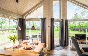 comedor con mesa y ventanas grandes en Lovely Home In Krems Ii-warderbrck With Sauna, en Göls