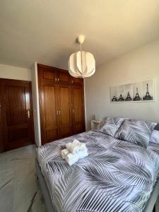 Preciosa vivienda con gran terraza muy luminoso في غرناطة: غرفة نوم عليها سرير وفوط