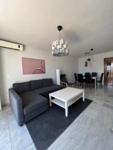 Preciosa vivienda con gran terraza muy luminoso في غرناطة: غرفة معيشة مع أريكة وطاولة
