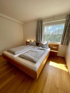 a bedroom with a large bed and a window at Pension & Gasthof zur Taube in Sulzberg