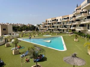 an apartment complex with a large swimming pool in a yard at Residencial Sabrina in Playas de Orihuela